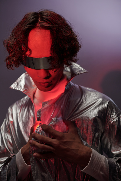 A male cyberpunk holds a red shining heart that illuminates his face