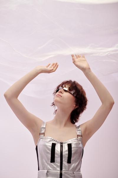 A Woman Looks Up Touches the Cellophane Coating Above Her