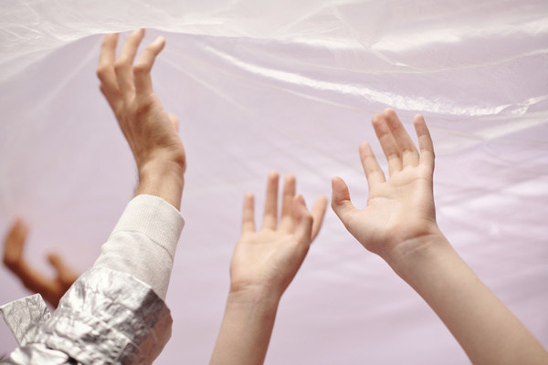 The Hands Touching Cellophane Material against a Light Background
