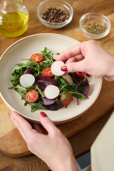 The Cook Puts Slices of Radish in a Plate