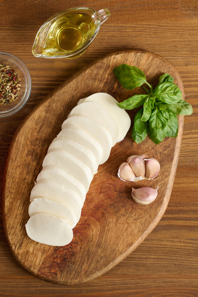 Sliced Mozzarella Cheese Basil Lie on a Chopping Board