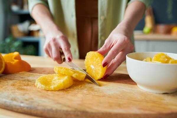 A Woman Slices an Orange for Smoothie