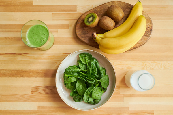 Smoothie and Spinach and Fruit on a Table