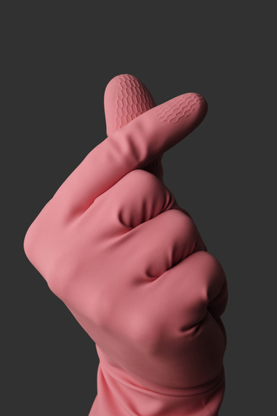 A man in pink rubber gloves shows a heart with his fingers