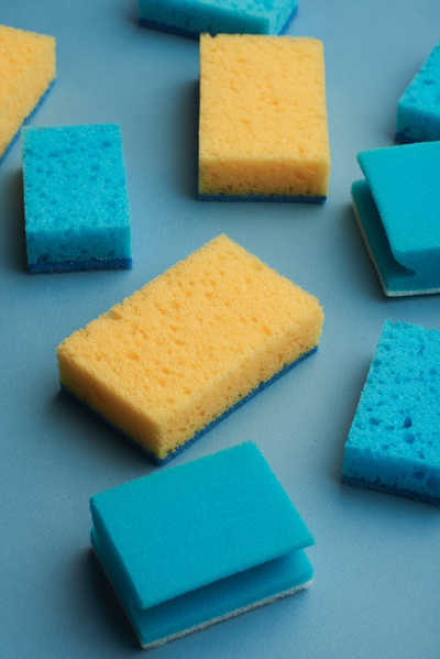 Blue and yellow cleaning sponges are randomly scattered on the blue surface