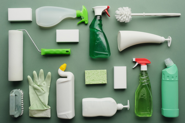 A large set for antimicrobial toilet cleaning consisting of household chemicals brushes sponges on a green surface