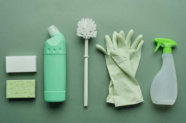 Antimicrobial toilet cleaning kit in white and green colors on a green surface