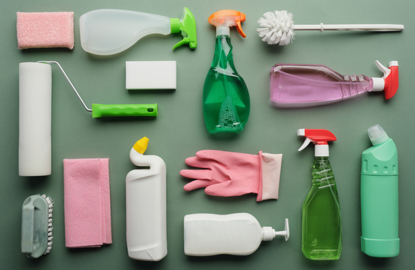 A large set for general cleaning of the toilet consisting of household chemicals brushes sponges and other cleaning devices on a green surface