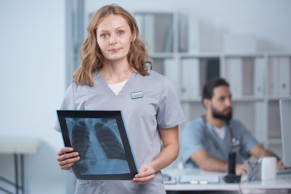 A female doctor in uniform with the results of an X-ray of the patient thoracic region