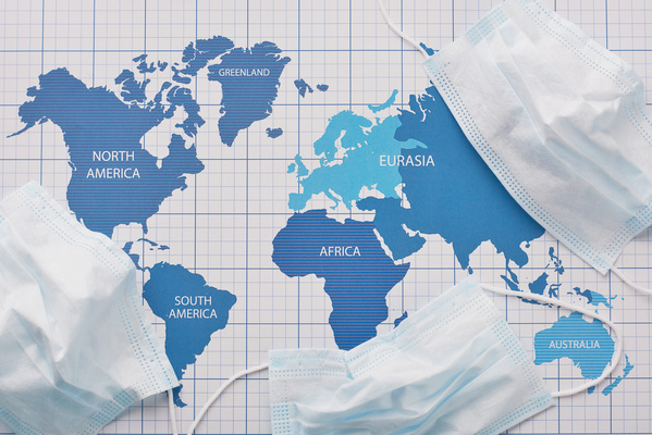 Crumpled disposable medical masks are scattered around the world map