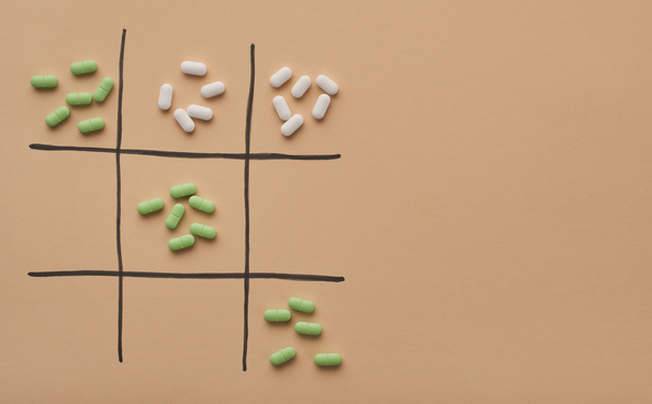 Oval pills of green and white color are spread out in handfuls on the field for tic-tac-toe