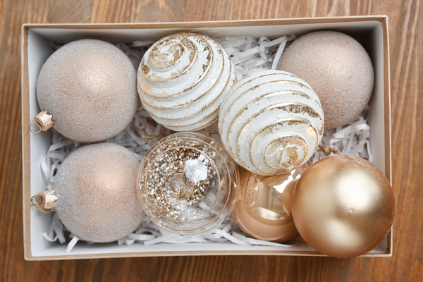 Christmas baubles of light shades are in a craft box with a white tissue paper