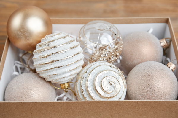 Christmas tree toys of white and gold color in a craft box with tissue paper