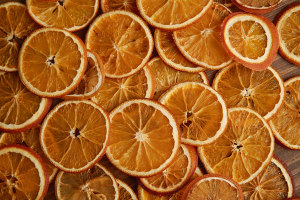 A pile of dried orange slices poured out on a wooden table