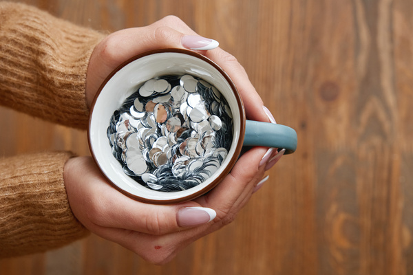 Blue mug with silver confetti in womens hands