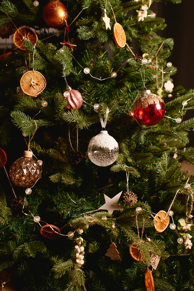 Christmas tree richly decorated with baubles garlands and dried fruit slices