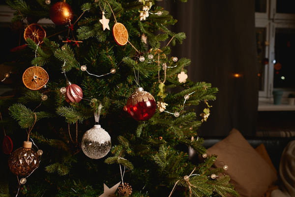 Christmas tree lavishly decorated with glass baubles garlands and dried fruit slices