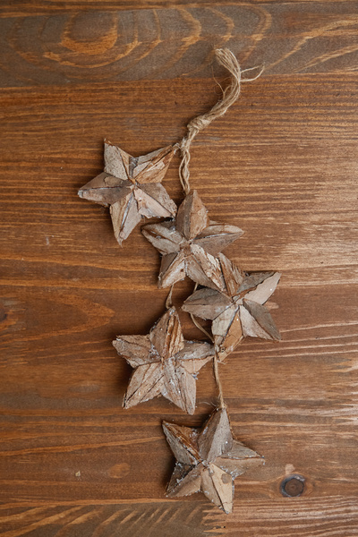 Christmas decoration made of three-dimensional wooden stars tied with twine on the table
