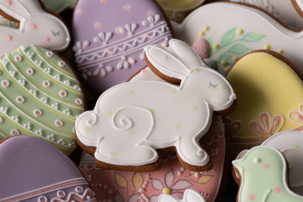 White glazed Easter gingerbread in the shape of a rabbit with light green polka dots in a bunch of gingerbread