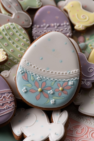 Glazed Easter gingerbread in the form of an egg with a floral pattern in a pile of gingerbread