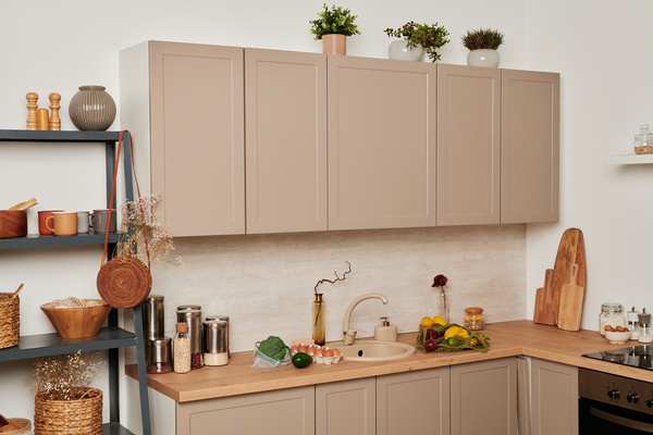 The interior of an eco friendly kitchen with a beige set with grocery shopping and a dark shelf with accessories