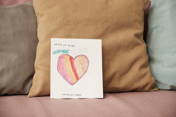 Homemade Fathers Day card with a bright illustration on a pink sofa with pillows