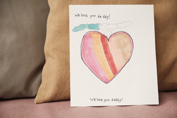 Handmade Fathers Day postcard with a bright pattern and congratulations on a pink sofa with pillows