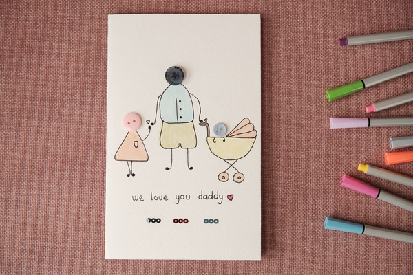 Handmade Fathers Day postcard decorated with button applique and a picture on a pink rag surface with felt-tip pens