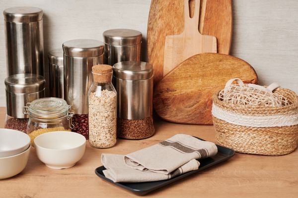 Eco-friendly glass and metal jars with grains on the kitchen table with eco-style accessories