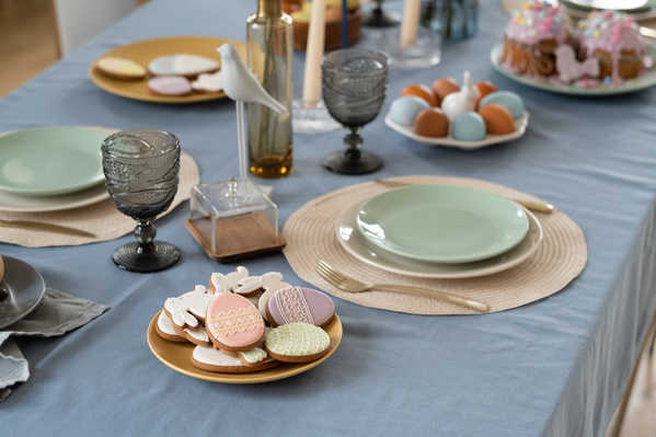 A festive Easter table in bright colors with a plate full of glazed gingerbread in a themed style
