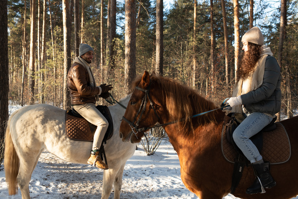 A Loving Couple Riding Horses in the Winter Forest