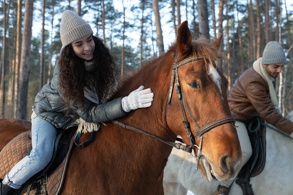 A Woman and Her Boyfriend Stroking Horses on a Horseback Riding