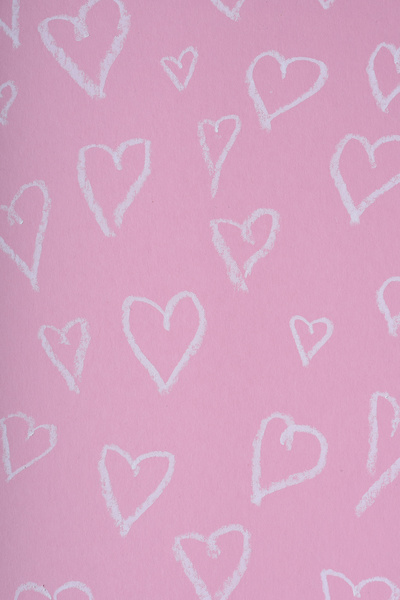 Hearts drawn in white chalk on a pink matte surface