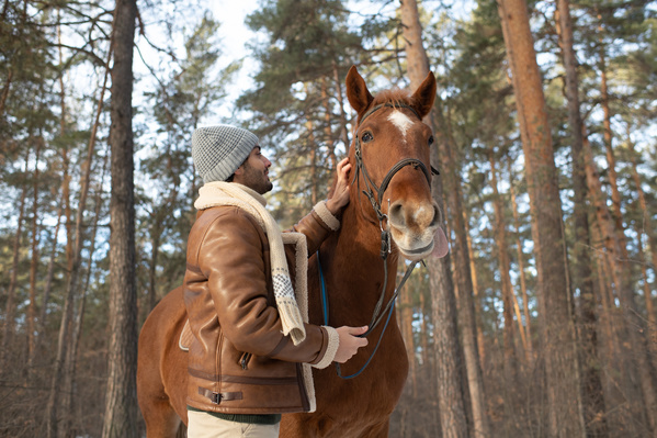 A Man Stroking a Horse in the Forest