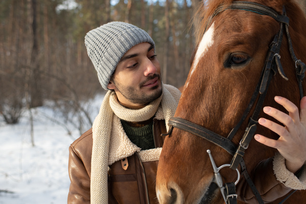 A Man with a Horse in the Winter Forest