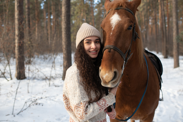 A Woman and a Brown Horse in the Forest