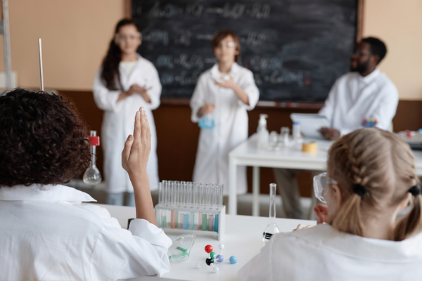A Group of People Wearing White Lab Coats in a Classroom