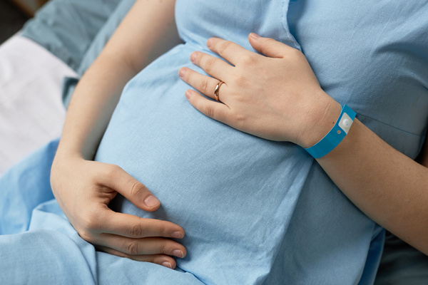 A Pregnant Woman Wearing a Blue Shirt and Bracelet